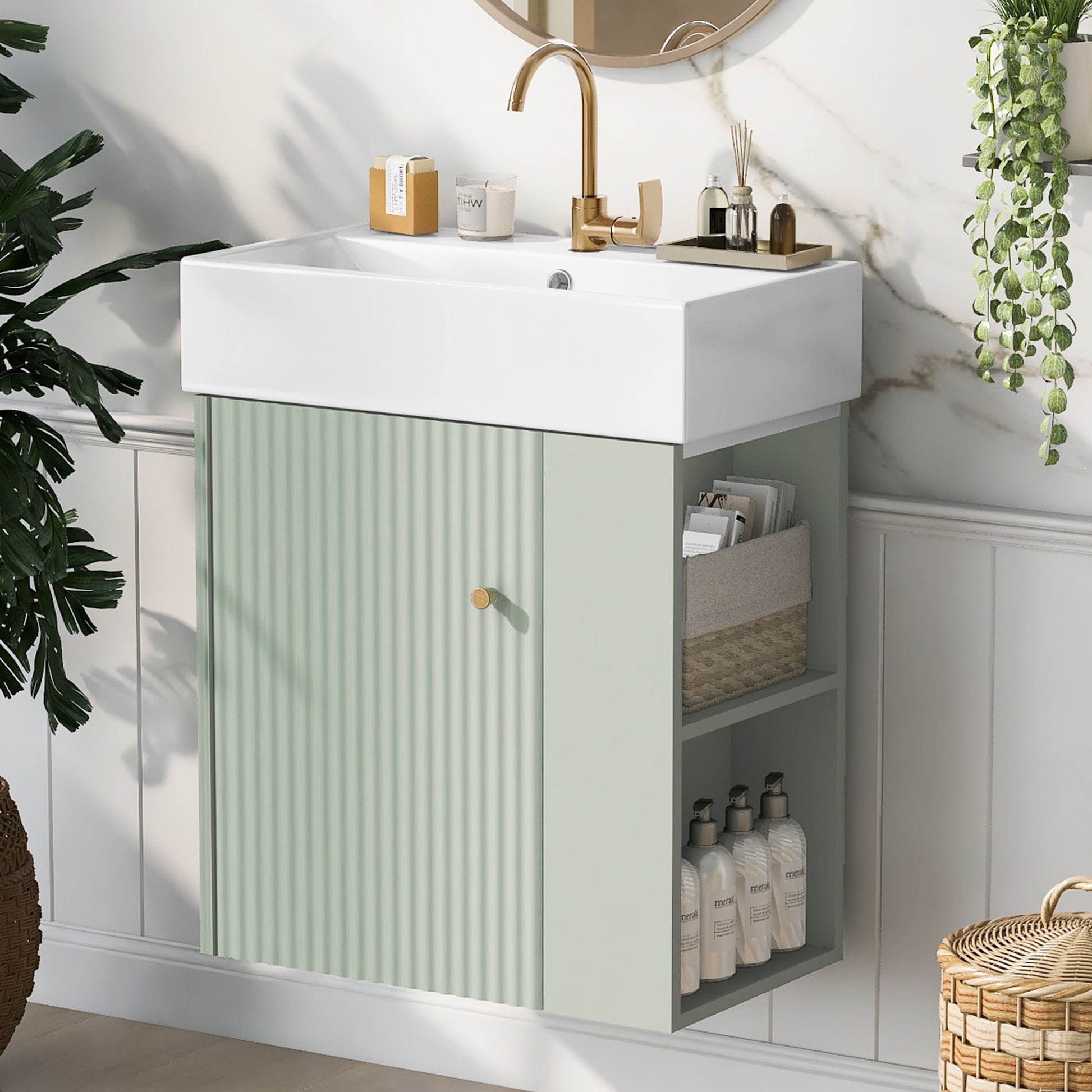 The Modern Floating Bathroom Vanity With Ceramic Basin features a white rectangular sink, gold faucet, and pastel green ribbed cabinet with open shelves for baskets and toiletries. Decorative plants and marble walls complete the look. Perfect for small bathrooms.