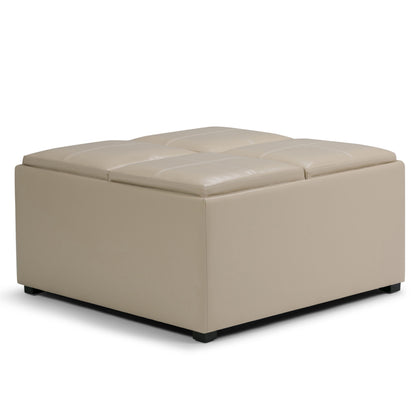 The Avalon Square Coffee Table, Storage Ottoman features a modern beige design with a cushioned tufted top, smooth sides, and small black feet.
