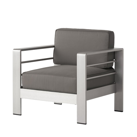 The Outdoor Aluminum Club Chair With Cushion - Gray features a matte silver metal frame, thick dark gray seat and back cushions, and a boxy design with straight lines and open armrests for a modern look.