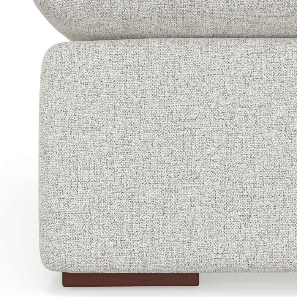 Close-up of the corner of the Jasmine - Handcrafted Sofa, featuring modern light gray textured upholstery and a short rectangular dark wooden leg.
