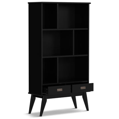The Draper - Mid Century Wide Bookcase And Storage Unit is a modern black bookshelf with six open shelves, two pull-out drawers at the bottom, and four angled legs.