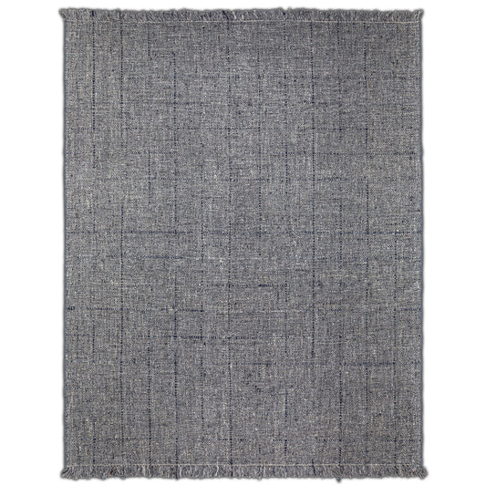 The Tenney Handcrafted Area Rug is rectangular and textured in gray, featuring subtle black lines in a loose grid pattern and short fringe on the edges.