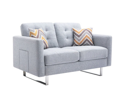 The Victoria Linen Fabric Loveseat features tufted cushions, sleek metal legs, side armrest pockets, and two zigzag-patterned pillows in yellow, gray, and white.
