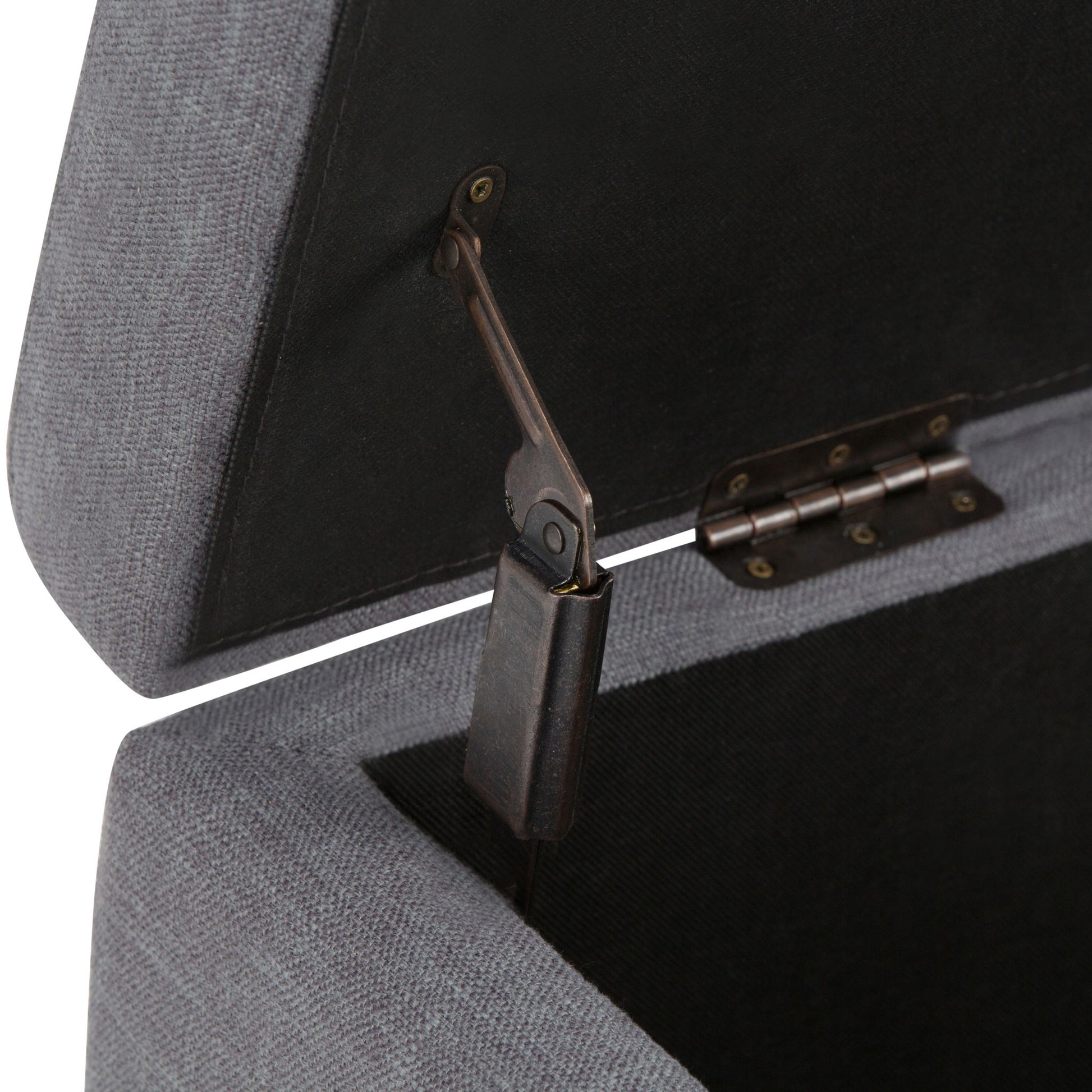 Close-up of the Hamilton - Upholstered Storage Ottoman in grey with its lid open, revealing the metallic hinge and support mechanism inside. The fabric texture and hardware details are clearly visible.