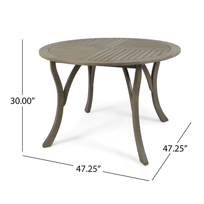 The Hermosa Outdoor Acacia Wood Table features a circular slatted top and four curved legs, measuring 47.25" in diameter and 30" high.