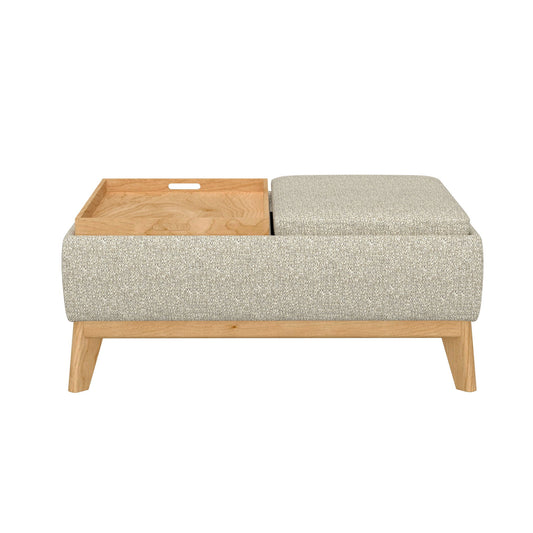 The Revel Reversible Tray Ottoman in tan features a cushioned seat on one side and a removable wooden tray on the other, with light wood legs, shown against a plain white background.