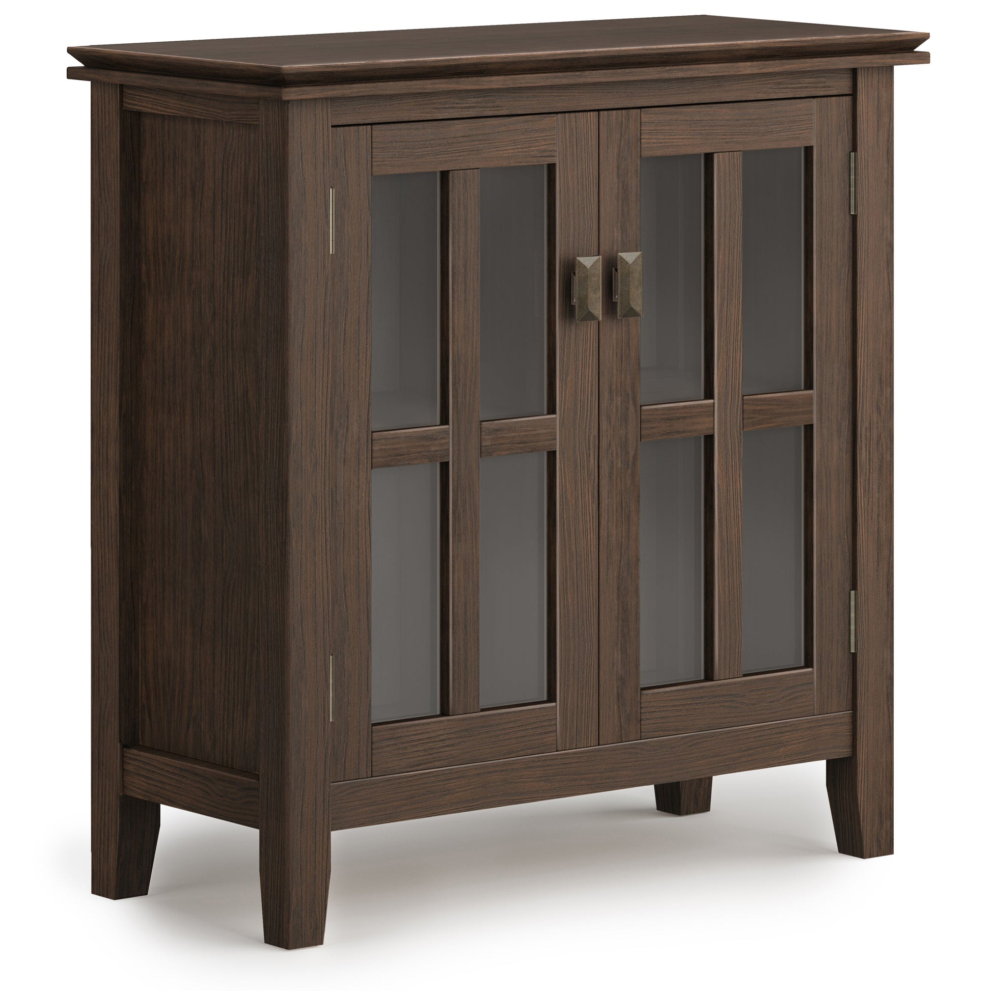 The Artisan - Handcrafted Low Storage Cabinet features dark wood, two glass-paneled doors with rectangular metal handles, four short legs, and a modern, simple design with vertical and horizontal wooden frames over the glass.