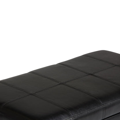 A close-up of the Amelia - Transitional Storage Ottoman Bench features a black leather cushion with visible square stitching, shown against a white background.