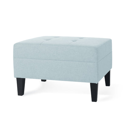 A Classic Ottoman with birch wood legs and fabric upholstery in light blue, featuring a rectangular shape, tufted top, and four black wooden legs, displayed against a white background.