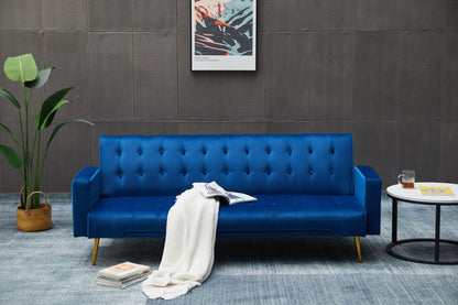 A modern living room features the Comfort Compact Design Sofa Bed in blue, topped with a white blanket, an open magazine, a potted plant nearby, a round side table with a drink, and wall art on a gray wall.