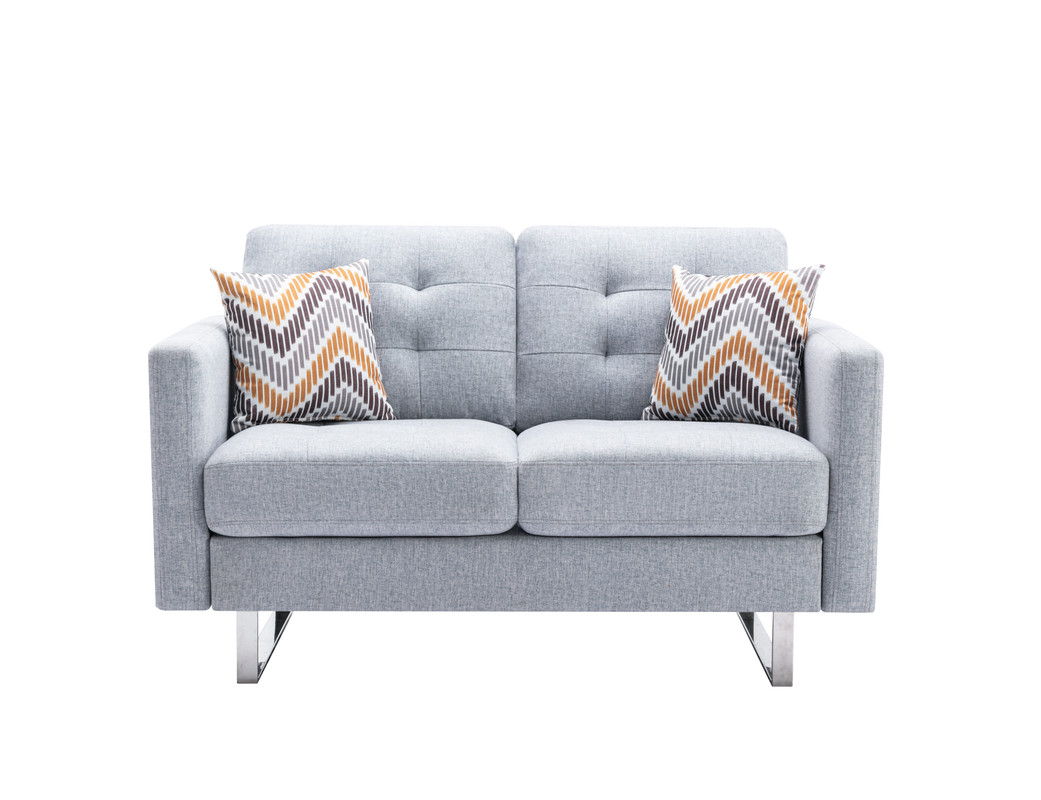 The Victoria loveseat features light gray linen fabric, a modern tufted back, square arms, metal legs, handy side pockets, and includes two chevron-patterned pillows in gray, white, and orange.