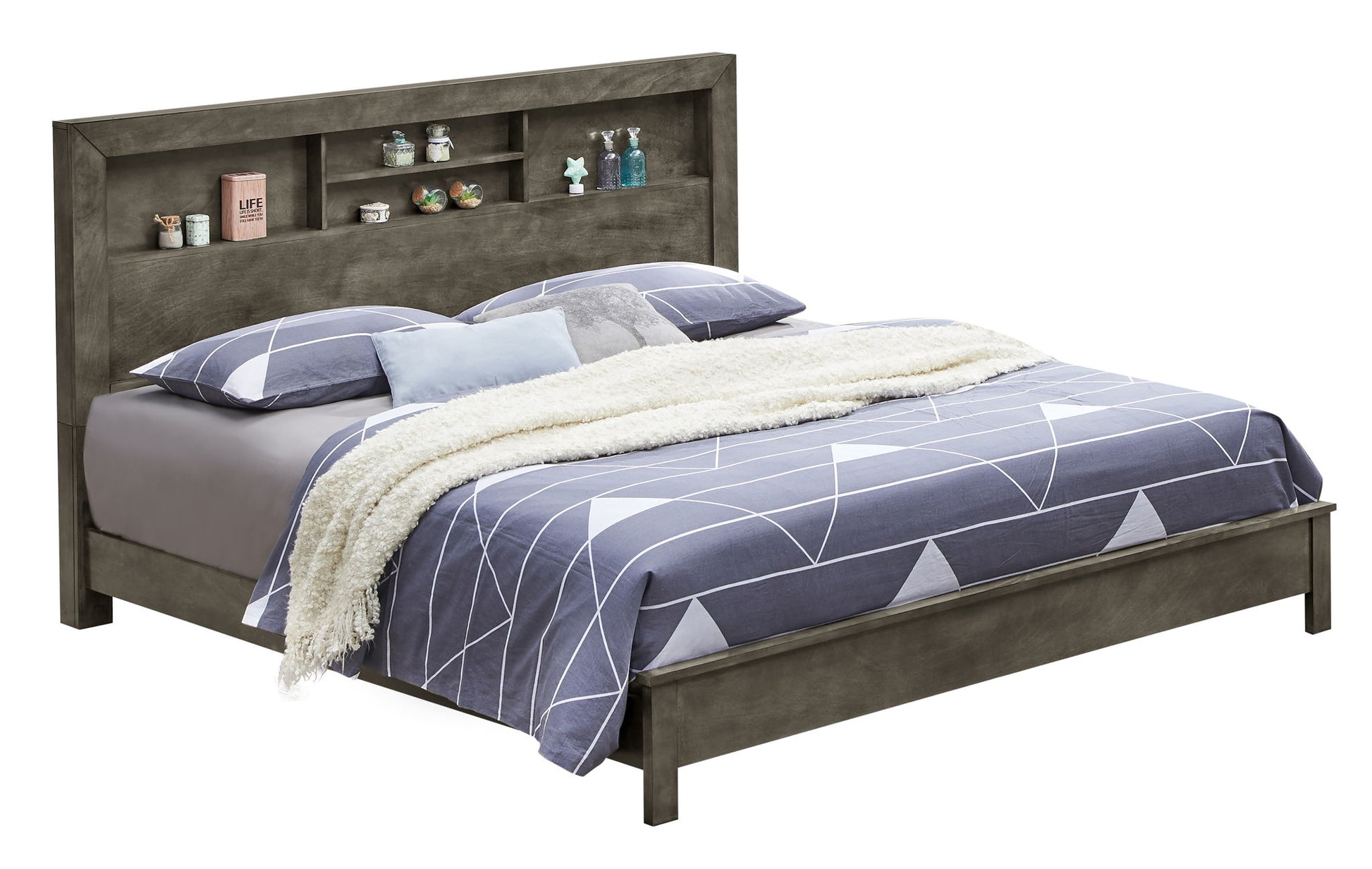 The Bed With Transitional Design Stylish features a geometric blue and white comforter, four pillows, a fluffy white throw, and a headboard with built-in shelves for books and decorative items.