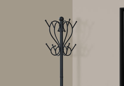 The Coat Rack, Hall Tree, Free Standing with 8 hooks and umbrella holder in transitional black stands against a beige wall, its shadow visible nearby and a dark rectangular doorway to the right.