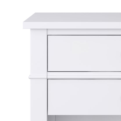 Close-up of the top left corner of the Carlton - Bedside Table, Handcrafted, featuring part of two drawers in a simple, modern white wooden design against a white background.