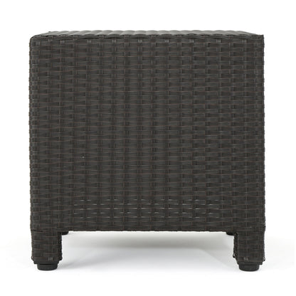 The Puerta - Minimalist Style Accent Table is a dark brown, square wicker outdoor side table with four short legs, shown from the side against a white background.
