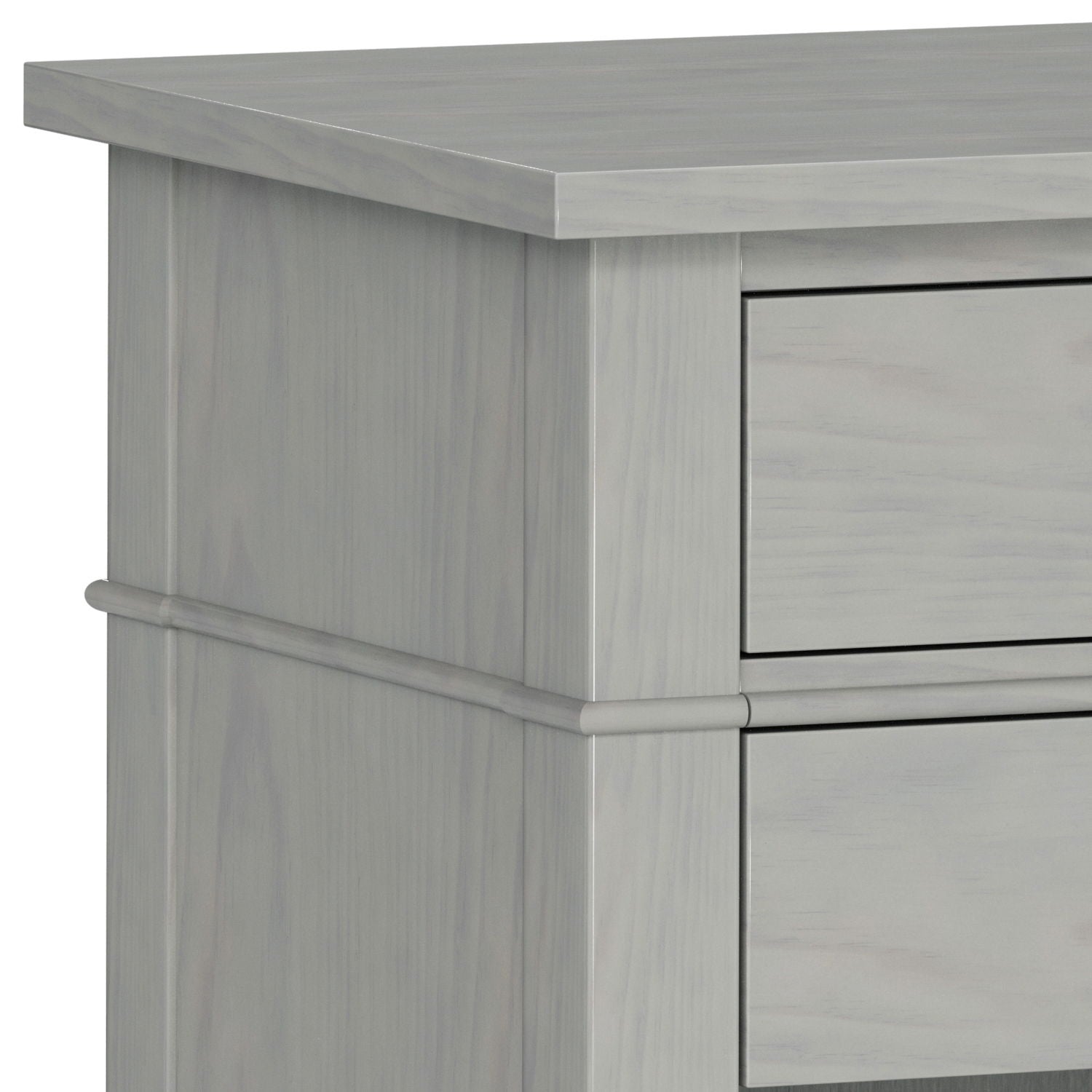 Close-up of the upper corner of the Carlton - Bedside Table, Handcrafted, in light gray wood, highlighting the smooth surface, clean lines, and part of two drawers.