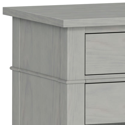 Close-up of the upper corner of the Carlton - Bedside Table, Handcrafted, in light gray wood, highlighting the smooth surface, clean lines, and part of two drawers.