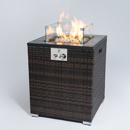 The Propane Gas Square Fire Pit features a tile tabletop, a stylish wicker base, and visible flames dancing over stones, perfect for outdoor settings.