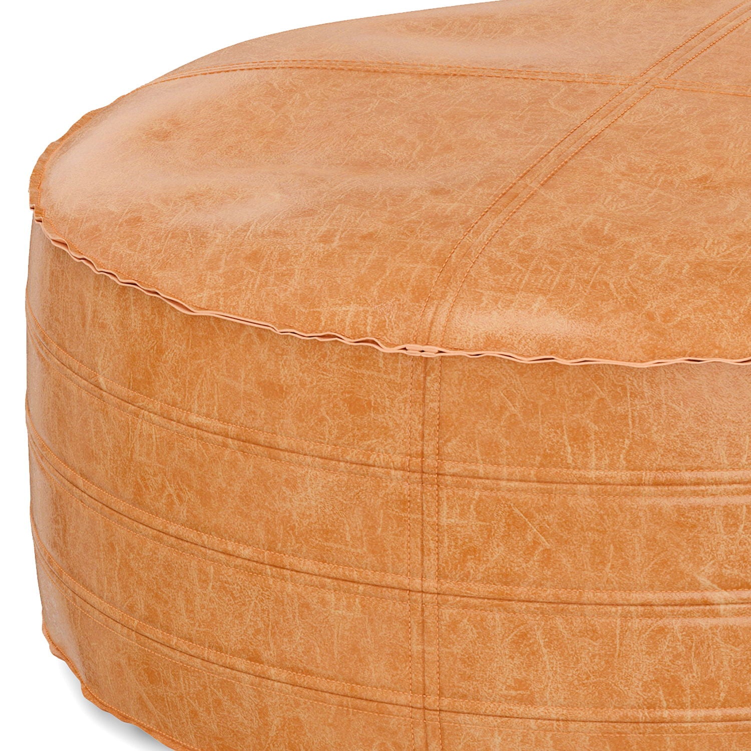 The Brody - Round Pouf features tan leather with visible stitching and subtle textured patterns. The photo highlights a close-up of its top and side.