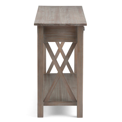 Side view of the Kitchener - Handcrafted Table featuring a rectangular top, open bottom shelf, X-shaped side braces, and a light weathered wood finish.