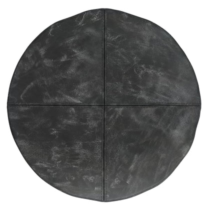 The Connor - Handcrafted Round Pouf features a black, leather-like surface divided into four equal sections with subtle lines, offering a textured and slightly worn look.