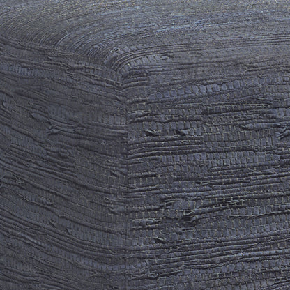 Close-up of the Fredrik - Handcrafted Square Pouf, highlighting its textured, dark fabric with woven horizontal and vertical patterns, subtle color variations, and raised details on the corner.