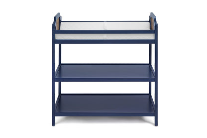 The Brees - Changing Table is a navy blue wooden table with two open shelves and a white cushioned changing pad on top, displayed against a plain white background.