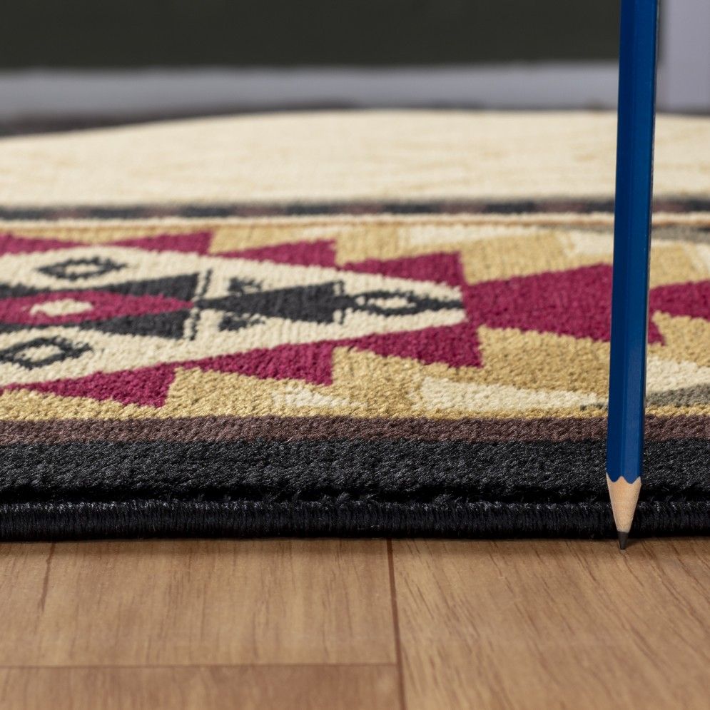 A close-up side view of the Tribes - GC_YLS4007 Southwest Area Rug on a wooden floor, with a blue pencil standing upright beside it to display the rug’s thickness.