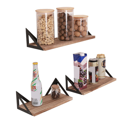 A set of three Floating Shelves, Long Wall Shelves (Natural Wood) are wall mounted with brackets in a minimalist display holding jars of nuts, beverage cans, a bottled drink, a small jar, and a carton.