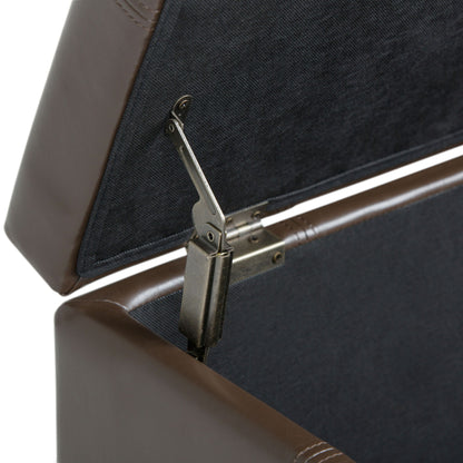 Close-up of the inside of the Dover - Upholstered Storage Ottoman Bench, featuring a sturdy metal hinge that keeps the lid open. The brown leather interior is lined with dark fabric for a refined look.