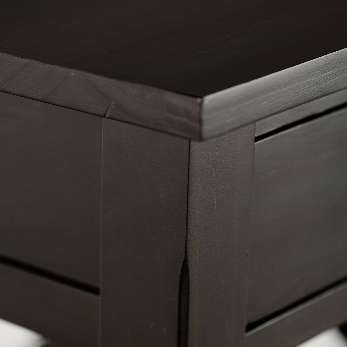 Close-up of the Kitchener - Handcrafted Table’s corner, highlighting its smooth, polished dark wood surface and clean, modern lines.