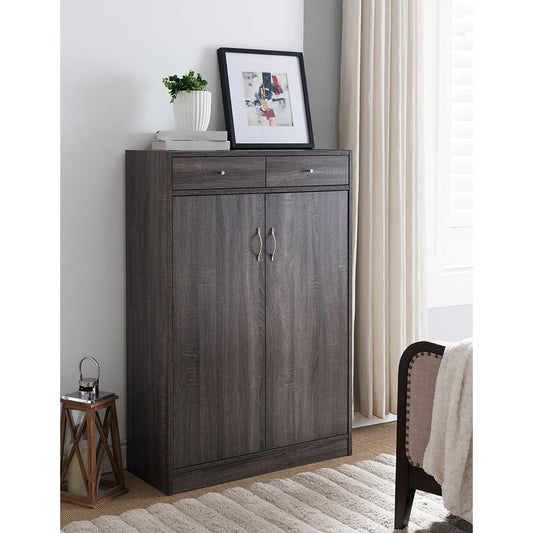 A dark wood Shoe Storage Cabinet with five shelves, two drawers, and room for 15 pairs of shoes stands by the bed. On top are a framed abstract artwork, potted plant, and small decor. Light curtains and a window complete the background.
