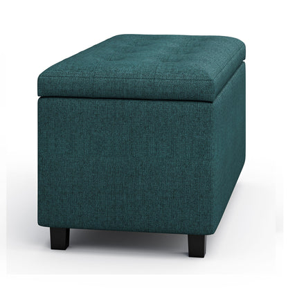 The Cosmopolitan Upholstered Storage Ottoman features a rectangular teal design with a cushioned top and short black legs, shown against a white background.