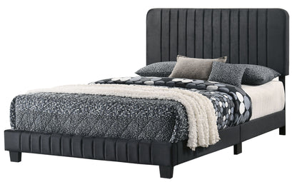 The Lodi - Bed features a tall, upholstered black headboard with a matching frame and black legs. It is styled with black and white patterned bedding, coordinating pillows, and a textured cream throw blanket for a modern look.