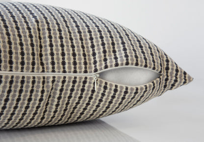 A close-up of a beige decorative throw pillow with a black checkered pattern and partially open zipper reveals the included white hypoallergenic square insert. The background is plain and light-colored.