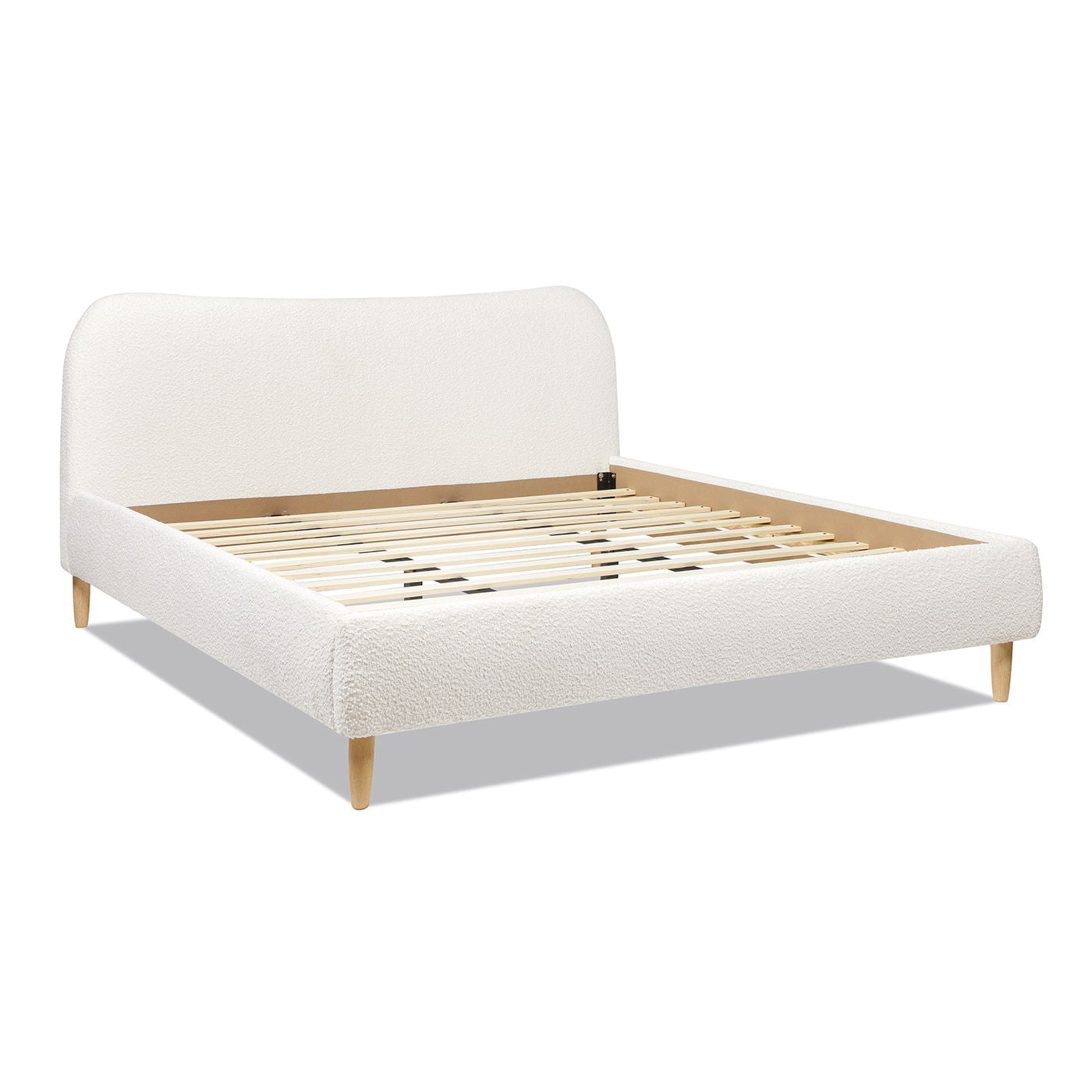 The Roman - Curved Headboard Upholstered Platform Bed features a soft white upholstered headboard and sides, sturdy wooden legs, and supportive wooden slats, shown here without a mattress on a plain white background.