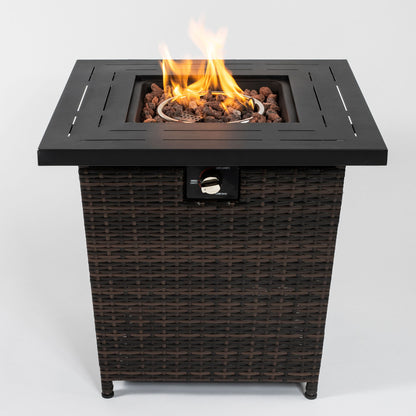 The 28" Wicker Square Fire Pit Table - Black Brown features a wicker base, black metal top, and a center with visible flames and lava rocks.