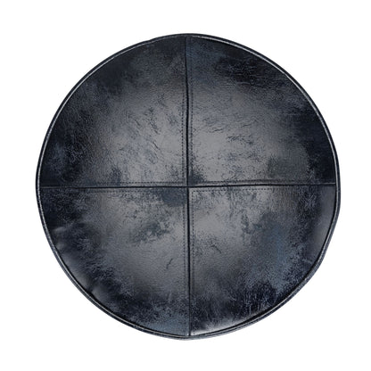 The Connor - Handcrafted Round Pouf features a shiny, slightly textured black leather seat with visible seams dividing it into four sections, shown from above.