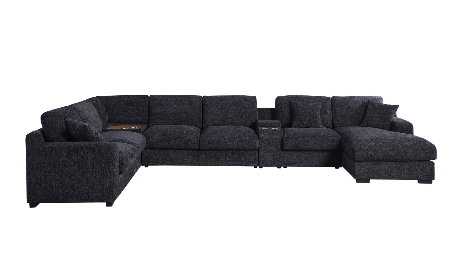 The large, dark gray Celine sectional is an L-shaped sofa in chenille fabric with plush cushions and a right-facing chaise. It includes built-in cup holders, charging ports, and a small storage compartment on the left section.