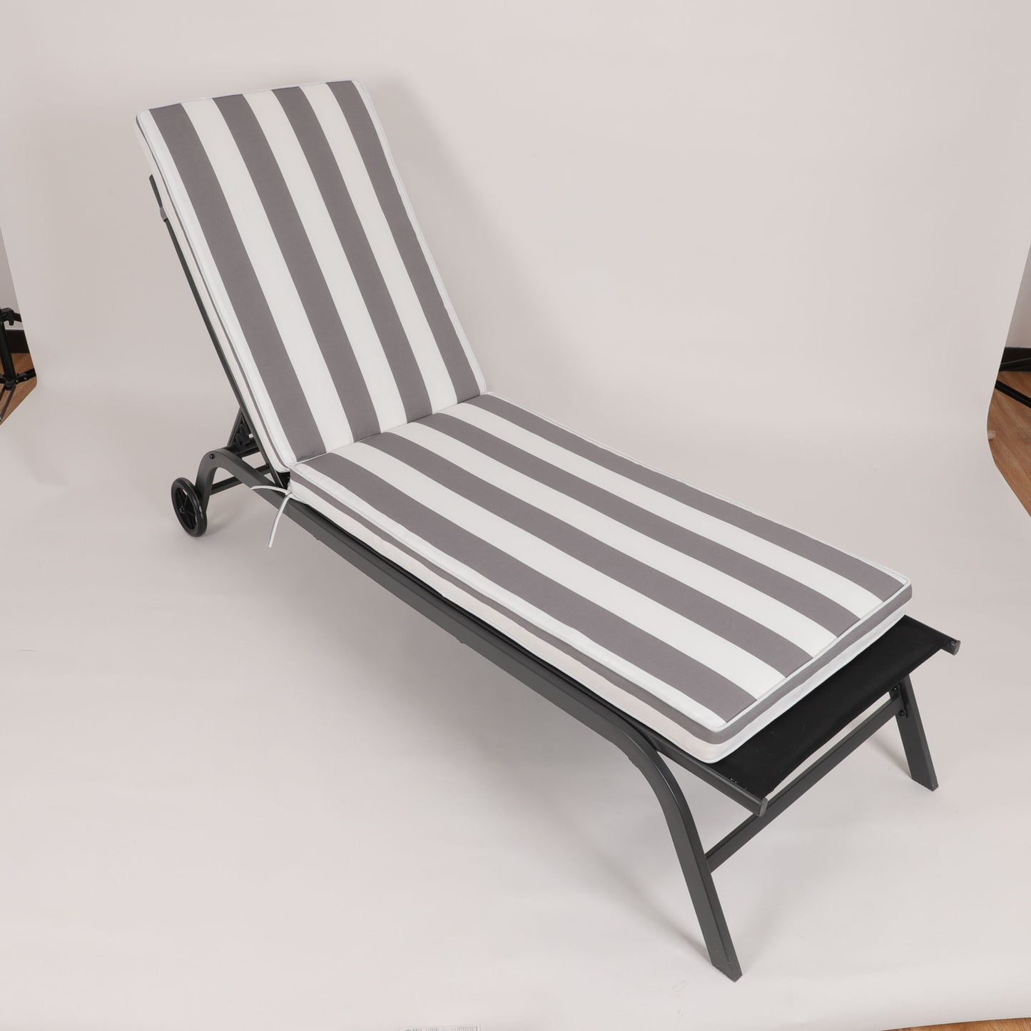A black metal outdoor lounge chair with the Outdoor Lounge Chair Cushion Replacement, featuring gray and white vertical stripes, set against a plain white background.