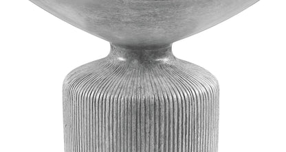 A close-up of the Laddie - Weathered Table, featuring a modern, metallic gray design with a rounded top and a textured, vertically ribbed cylindrical base against a white background.