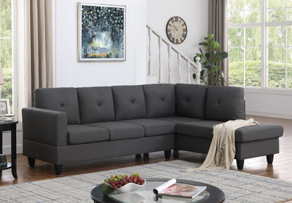 A modern living room with the Santiago Linen Sectional Sofa with right facing chaise in dark gray, a round coffee table holding fruit and books, a wall clock, leafy plant, large windows with light curtains, and a framed abstract painting.