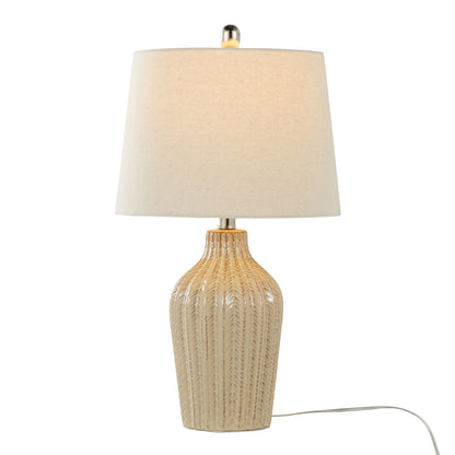 The Rockwell - Contemporary Table Lamp (Set of 2) features a beige ceramic textured base and cream fabric shade, shown turned on with visible power cord against a white background.