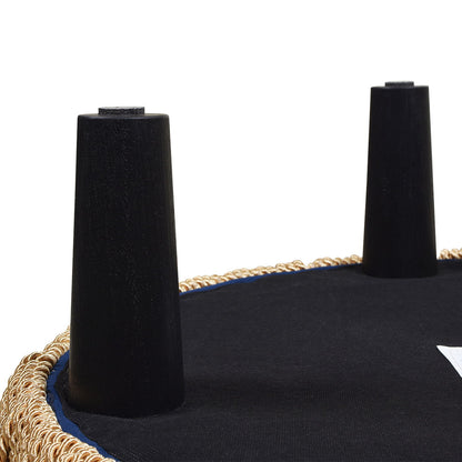 A close-up of the underside of the Yolanda - Round Upholstered Accent Ottoman with two black cylindrical legs, set against a plain white background.