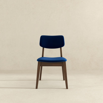 A Carlos Solid Back Side Chair (Set of 2) with blue upholstered seat and backrest is centered against a plain, light beige background.