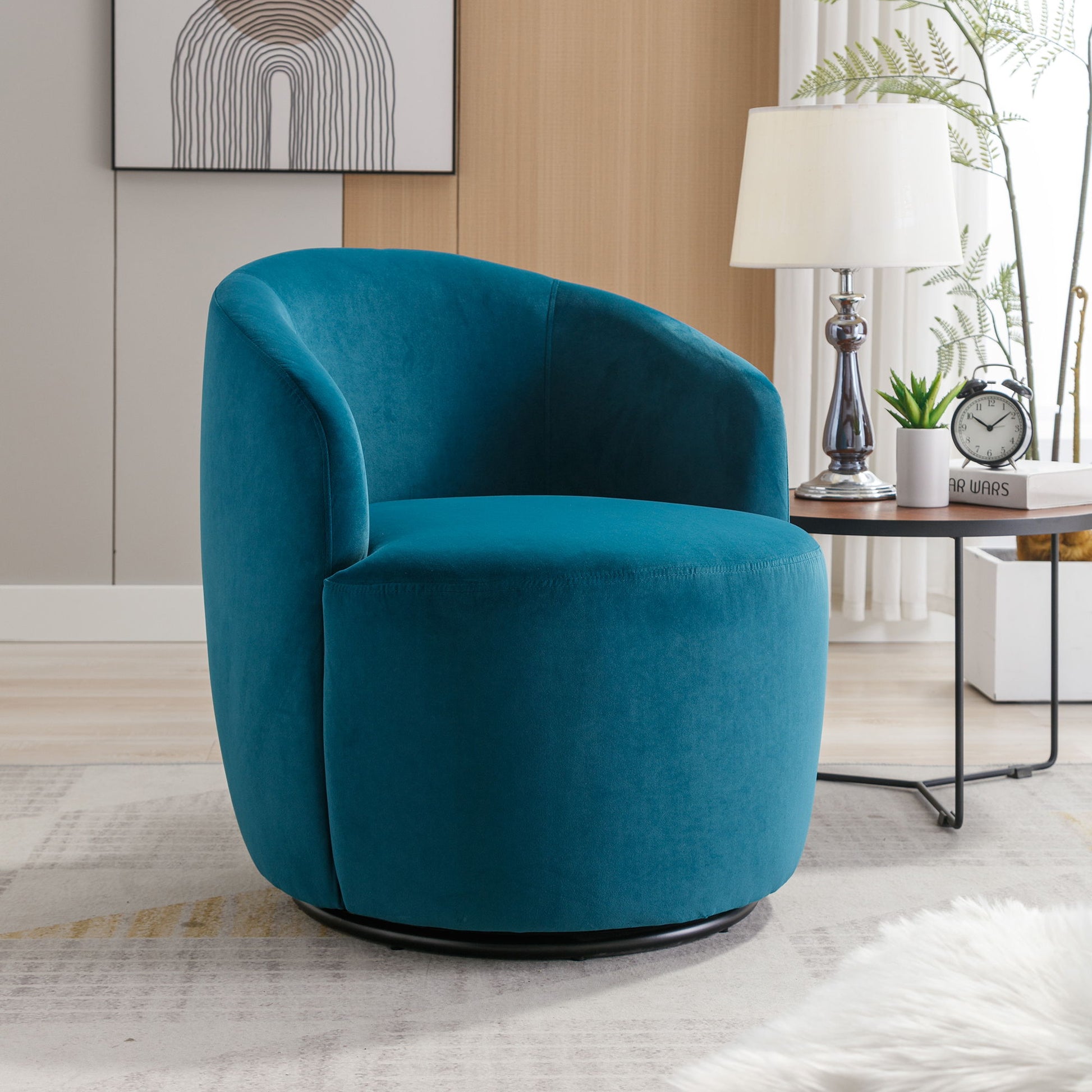 A Velvet Fabric Swivel Accent Armchair Barrel Chair with a powder-coated metal ring in teal sits in a bright living room by a round side table, lamp, clock, potted fern, abstract wall art, and light rug for contemporary style.