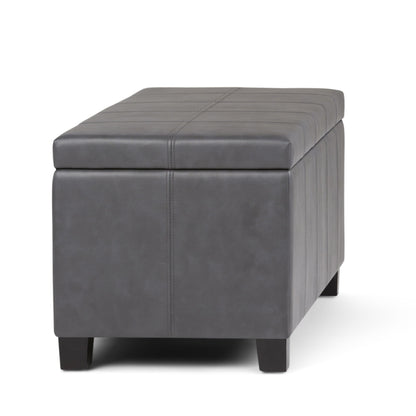 The Dover Upholstered Storage Ottoman Bench is a rectangular, dark gray ottoman with visible stitching and short black legs, shown on a white background.