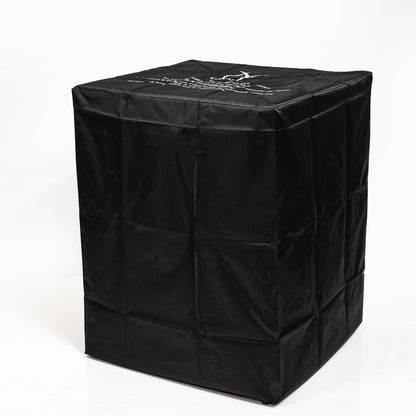 A large black fabric cover with stitched seams and printed text, slightly shiny, fits over the Propane Gas Square Fire Pit with a tile tabletop and wicker base, shown against a plain white background.