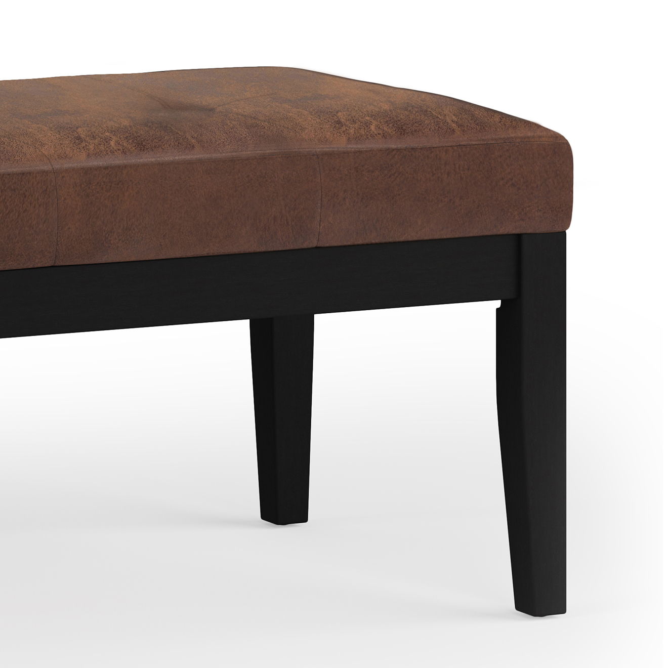 A close-up view of the Lacey - Upholstered Tufted Ottoman Bench featuring a brown cushioned seat and black wooden legs, set against a white background.