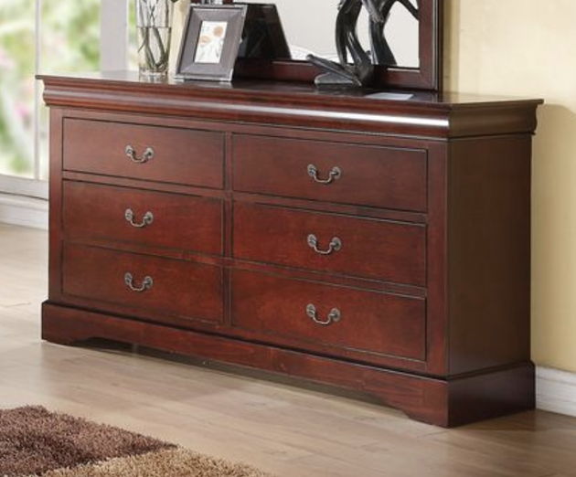 The Louis Philippe III Dresser features durable dark wood construction, six drawers with metal handles, and a matching framed mirror. Set on a light wood floor, the dresser is topped with framed photos and decor for added style.